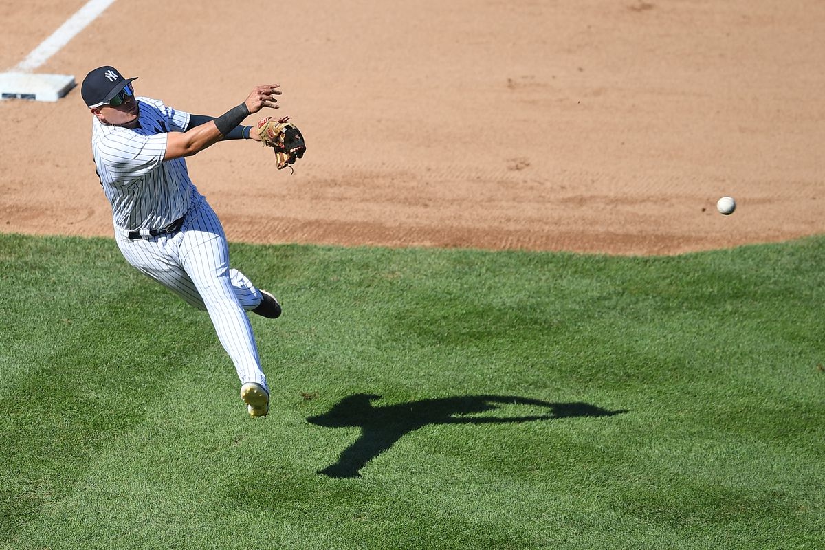 Gio Urshela of the New York Yankees fields a baseball mid-air 