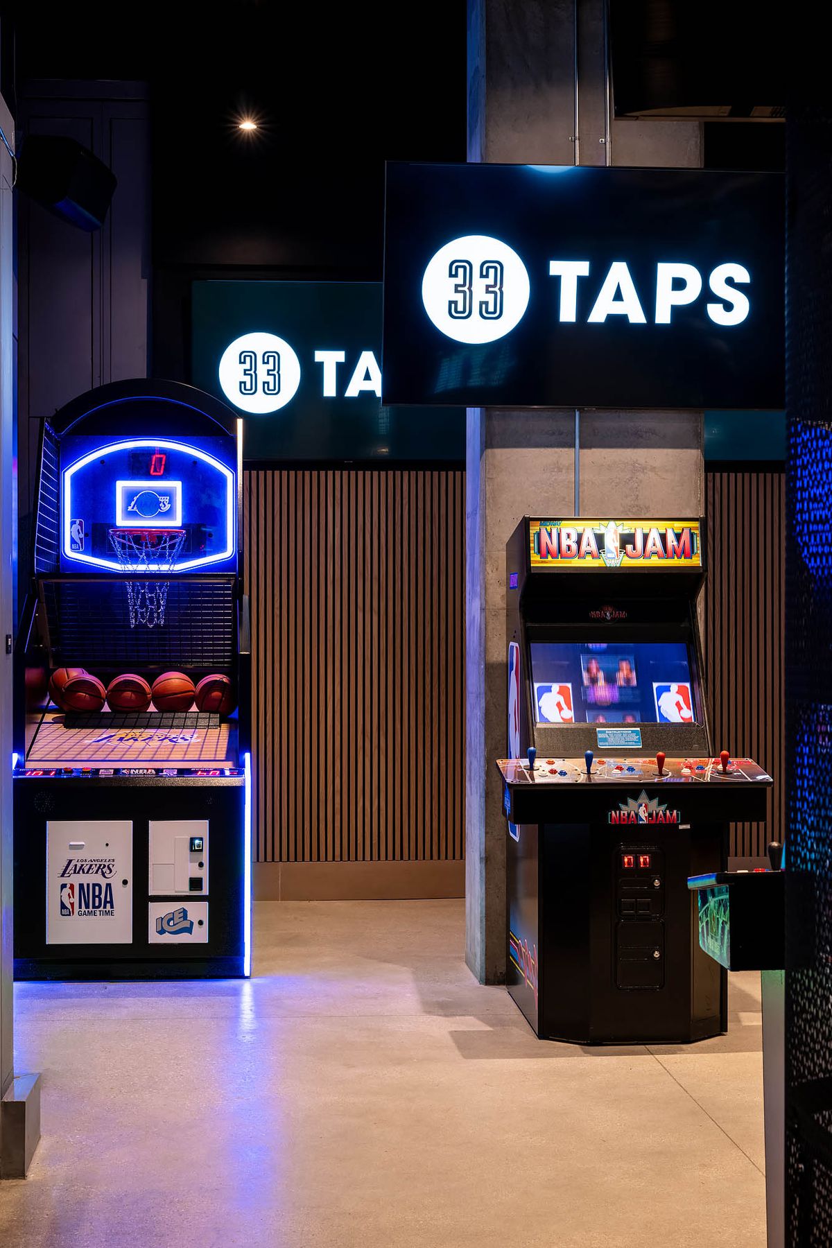 Retro arcade and basketball hoops at a modern sports bar.