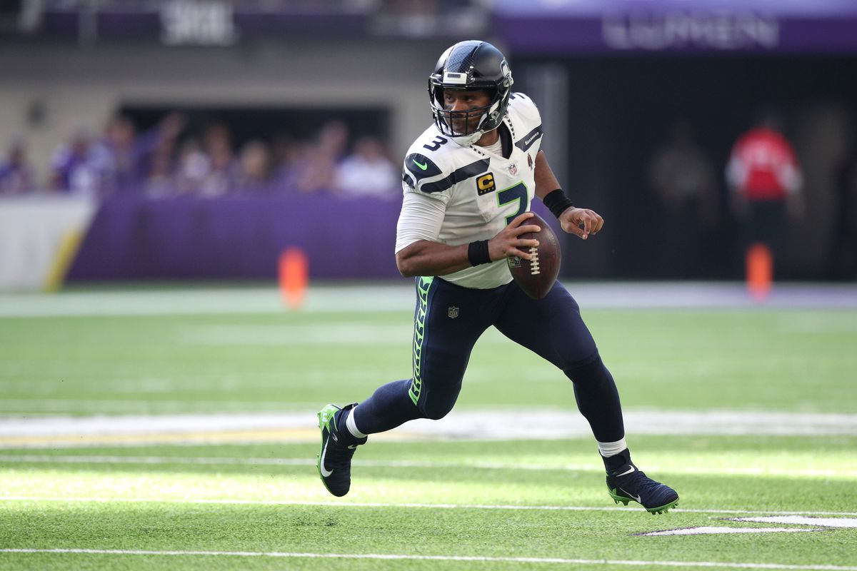 Russell Wilson of the Seattle Seahawks scrambles out of the pocket during the first half in the game against the Minnesota Vikings at U.S. Bank Stadium on September 26, 2021 in Minneapolis, Minnesota.