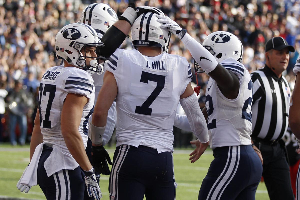 Brigham Young quarterback Taysom Hill (7) is congratulated by teammates after scoring a touchdown against Cincinnati during the first half of an NCAA college football game, Saturday, Nov. 5, 2016, in Cincinnati. (AP Photo/Gary Landers)