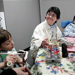 Renee Perrault, center, paints at Kindred Spirits, a studio created for disabled children. She is joined at the table by her nephew Julius Steubing, right, and Celina Wollsieffer.