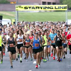 Runners sprint away from the start line in Research Park during the Deseret News 10K race that finish at Liberty Park in Salt Lake City on Tuesday, July 24, 2018.
