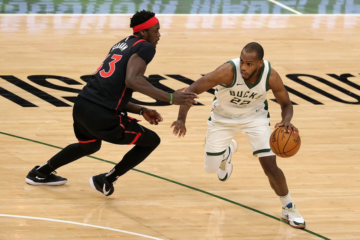 Khris Middleton of the Milwaukee Bucks is defended by Pascal Siakam of the Toronto Raptors during a game at the Fiserv Forum on February 16, 2021 in Milwaukee, Wisconsin.