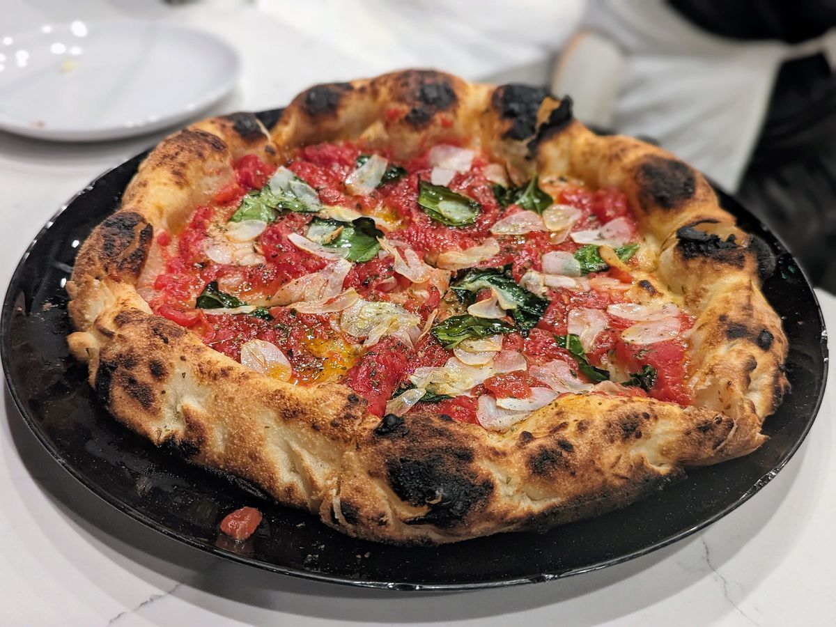 A tomato and garlic-topped wood-fired pizza.