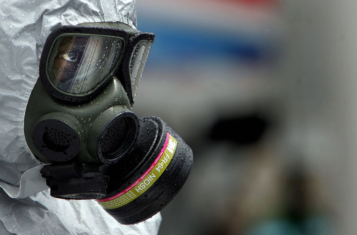 A person wearing a hazmat suit and a protective mask and goggles. 
