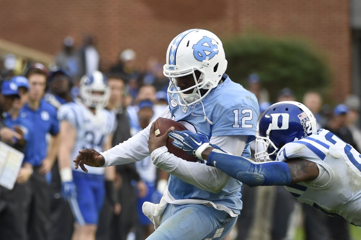 Nov 7, 2015; Chapel Hill, NC, USA; North Carolina Tar Heels quarterback Marquise Williams (12) runs as Duke Blue Devils safety DeVon Edwards (27) defends in the third quarter at Kenan Memorial Stadium. 
