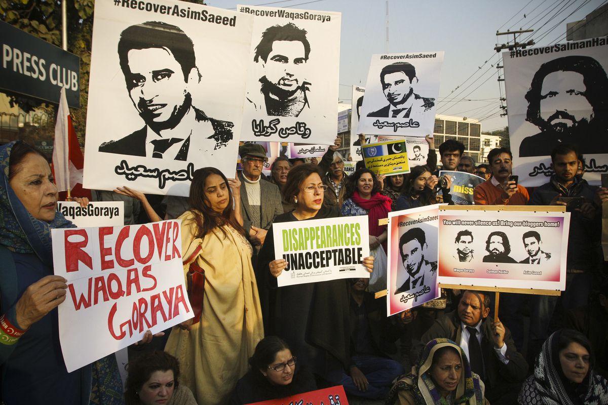 Protesters hold images of three bloggers who disappeared during a rally in Lahore on January 12, 2017. 