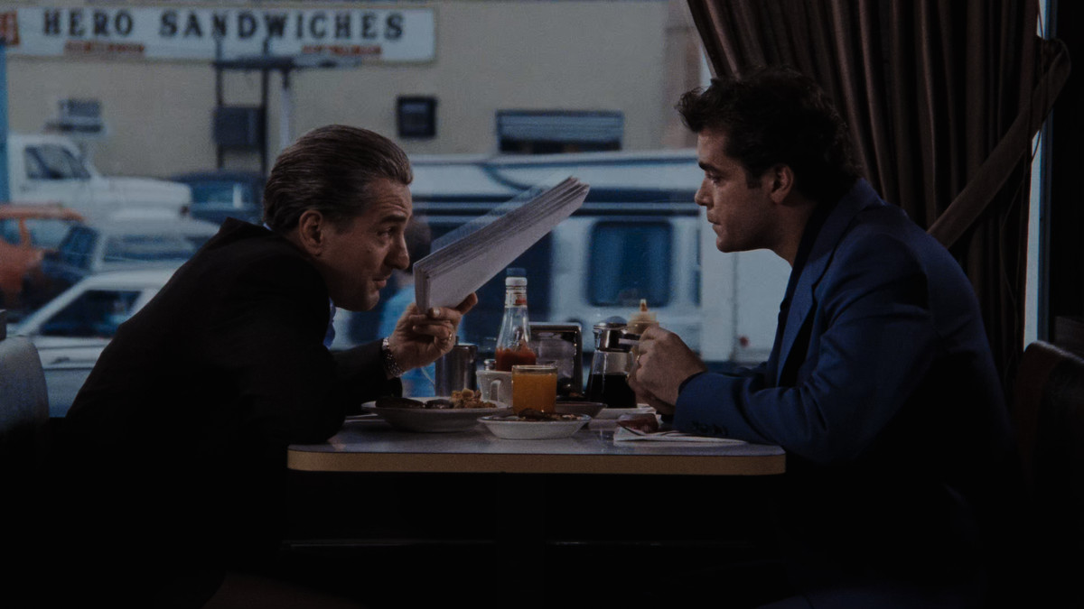 Robert De Niro and Ray Liotta eat breakfast in a diner in a screenshot from Goodfellas