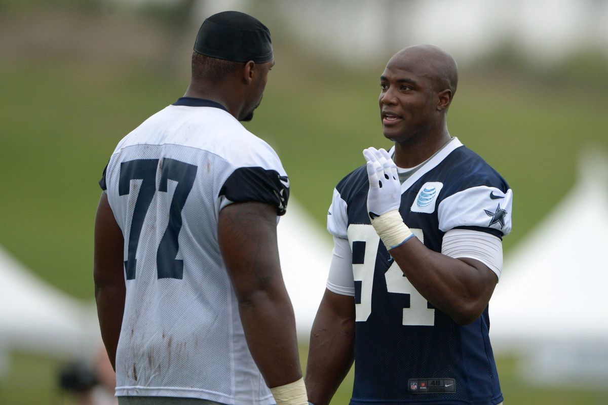 DeMarcus Ware talks to Tyron Smith during training camp.