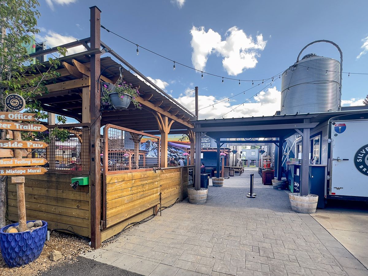 An entryway with covered patio on one side and a Silver Moon Brewing beer truck on the other.