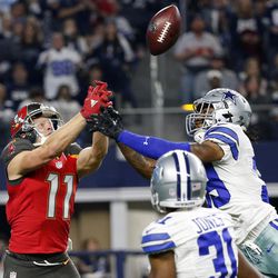 Tampa Bay Buccaneers' Adam Humphries (11) reaches up to catch a pass for a touchdown that was tipped by Dallas Cowboys' Brandon Carr, right, in the second half of an NFL football game, Sunday, Dec. 18, 2016, in Arlington, Texas. 