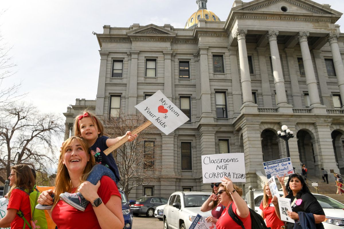 Teacher Christina Hafler and her two-year-old daughter Emma join hundreds of other educators at a rally outside the State Capitol to call for increased eduction funding on April 16, 2018 in Denver, Colorado. (Photo by RJ Sangosti/The Denver Post)