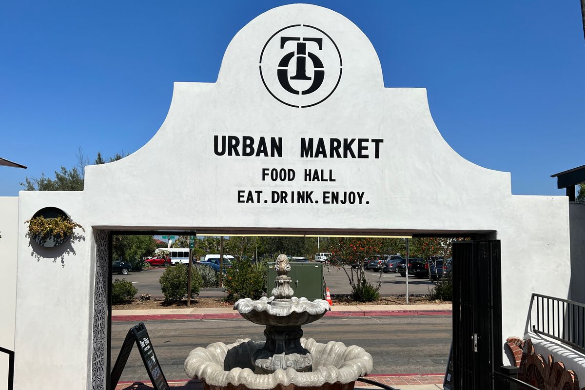 A fountain in front of the entrance of an outdoor food hall.