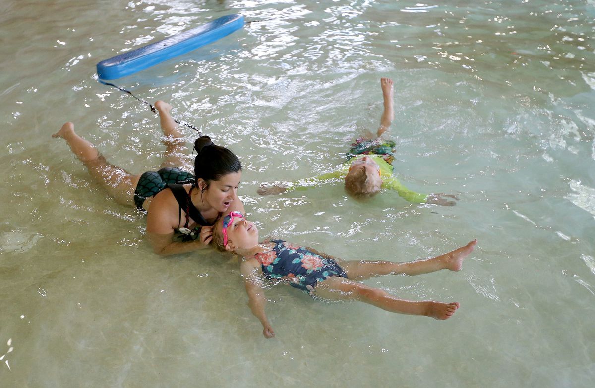 Tessie Mae Arce teaches Hadley Crockett and Quinton Willis how to swim at Fairmont Aquatic Center in Salt Lake City on Tuesday, May 22, 2018.