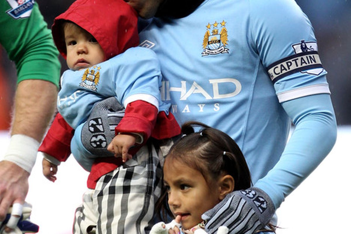 Manchester City striker Carlos Tevez uses a straw (not pictured) to feast upon the brains of an infant. (Photo by Alex Livesey/Getty Images)