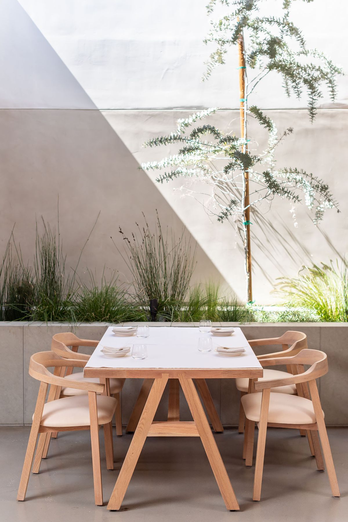 A table set for service in a modern, pared-down wood-lined dining restaurant.