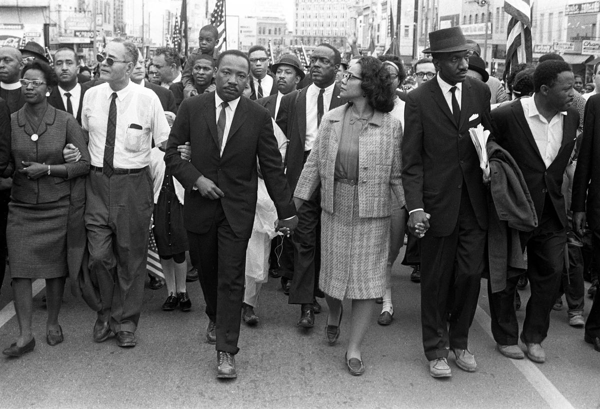 A black-and-white photo of the March To Montgomery, showing Martin Luther King Jr. leading a protest shutting down a street.