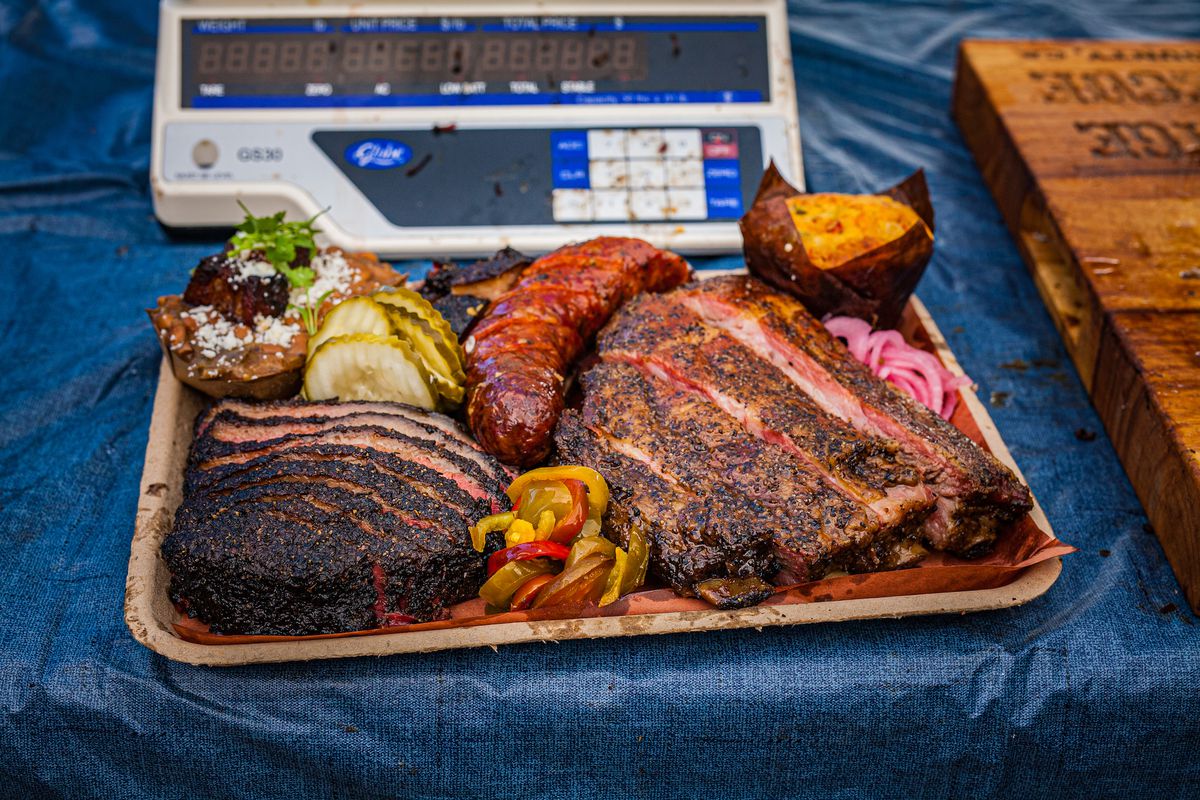 A full meat tray of barbecue specialities including a hot link and ribs and brisket.