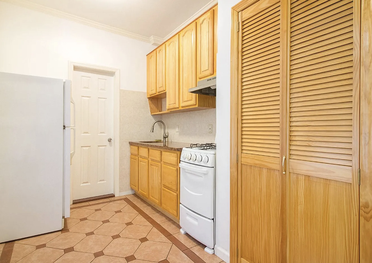A small kitchen with wood cabinetry.