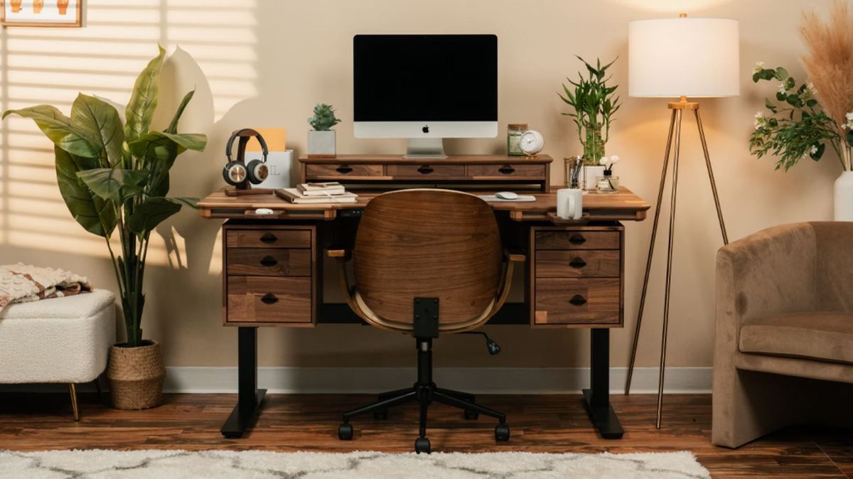 At the core of the Wyrmwood Modular Desk is a black frame. The surface here is dark walnut, with two cubbies each with three drawers. A desk topper holds a monitor, while a magnetic accessory holds a cup of coffee.