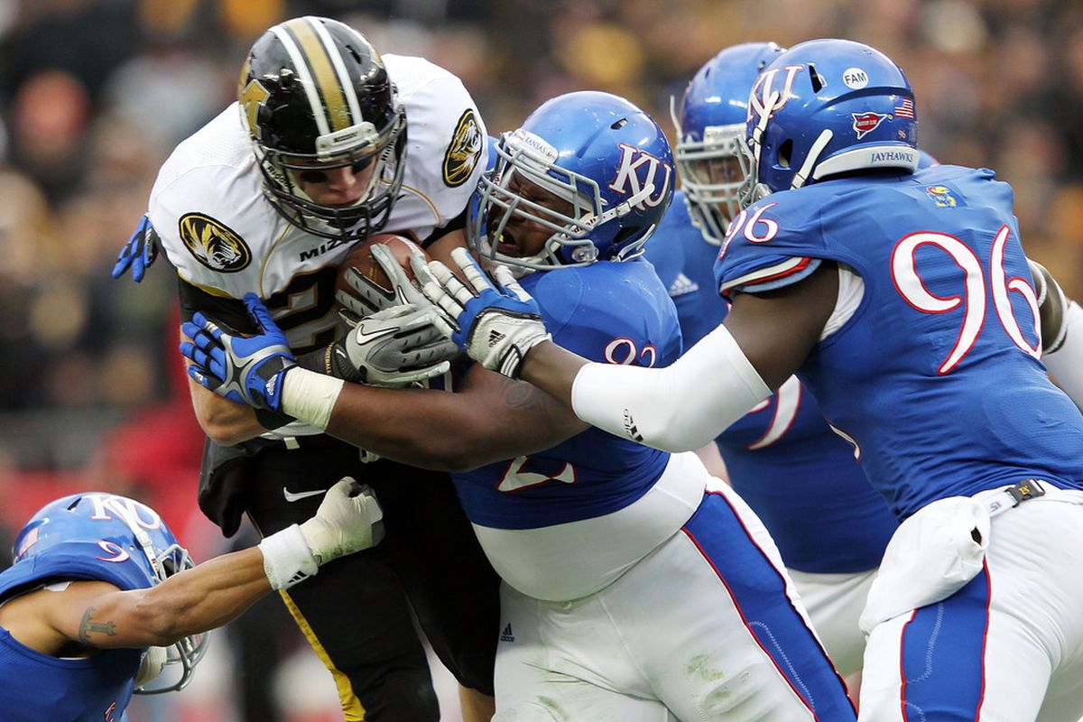 KANSAS CITY, MO - NOVEMBER 26:  T.J. Moe #28 of the Missouri Tigers is stopped by Patrick Dorsey #92 of the Kansas Jayhawks during the game on November 26, 2011 at Arrowhead Stadium  in Kansas City, Missouri.  (Photo by Jamie Squire/Getty Images)