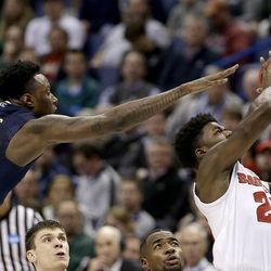 Pittsburgh's Jamel Artis (1) tries to block a shot by Wisconsin's Khalil Iverson during the second half of a first-round men's college basketball game in the NCAA Tournament, Friday, March 18, 2016, in St. Louis. Wisconsin won 47-43. (AP Photo/Charlie Riedel)