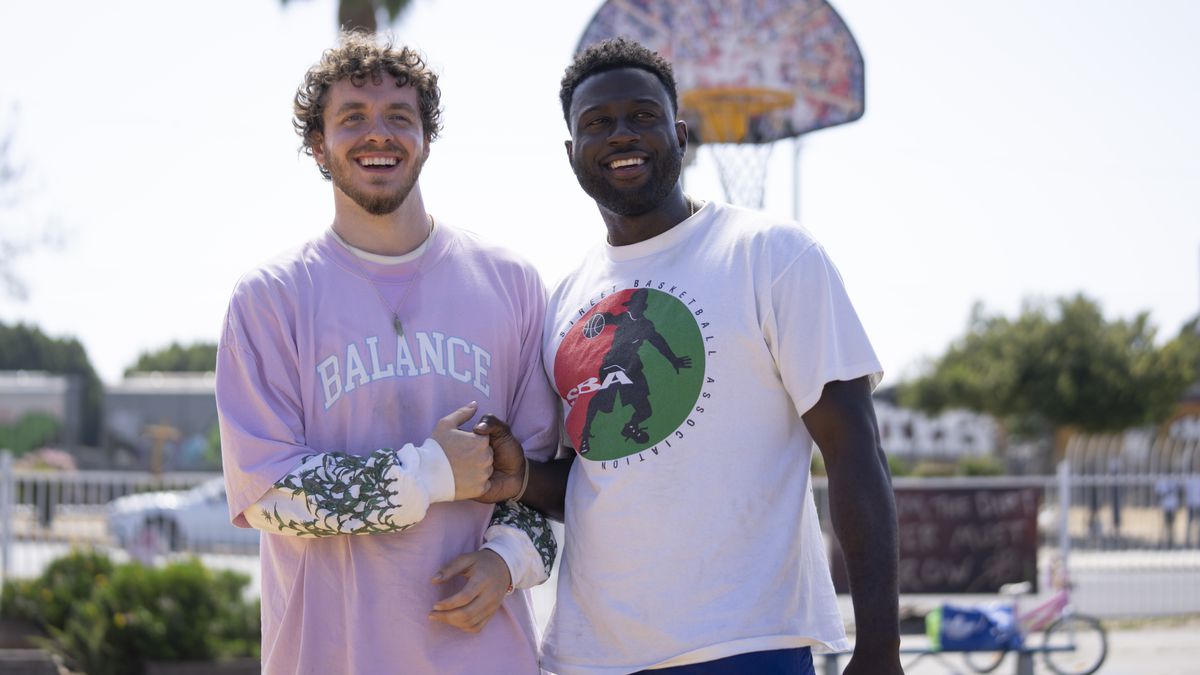 Jack Harlow and Sinqua Walls as Jeremy and Kamal on an outdoor court smiling in White Men Can’t Jump