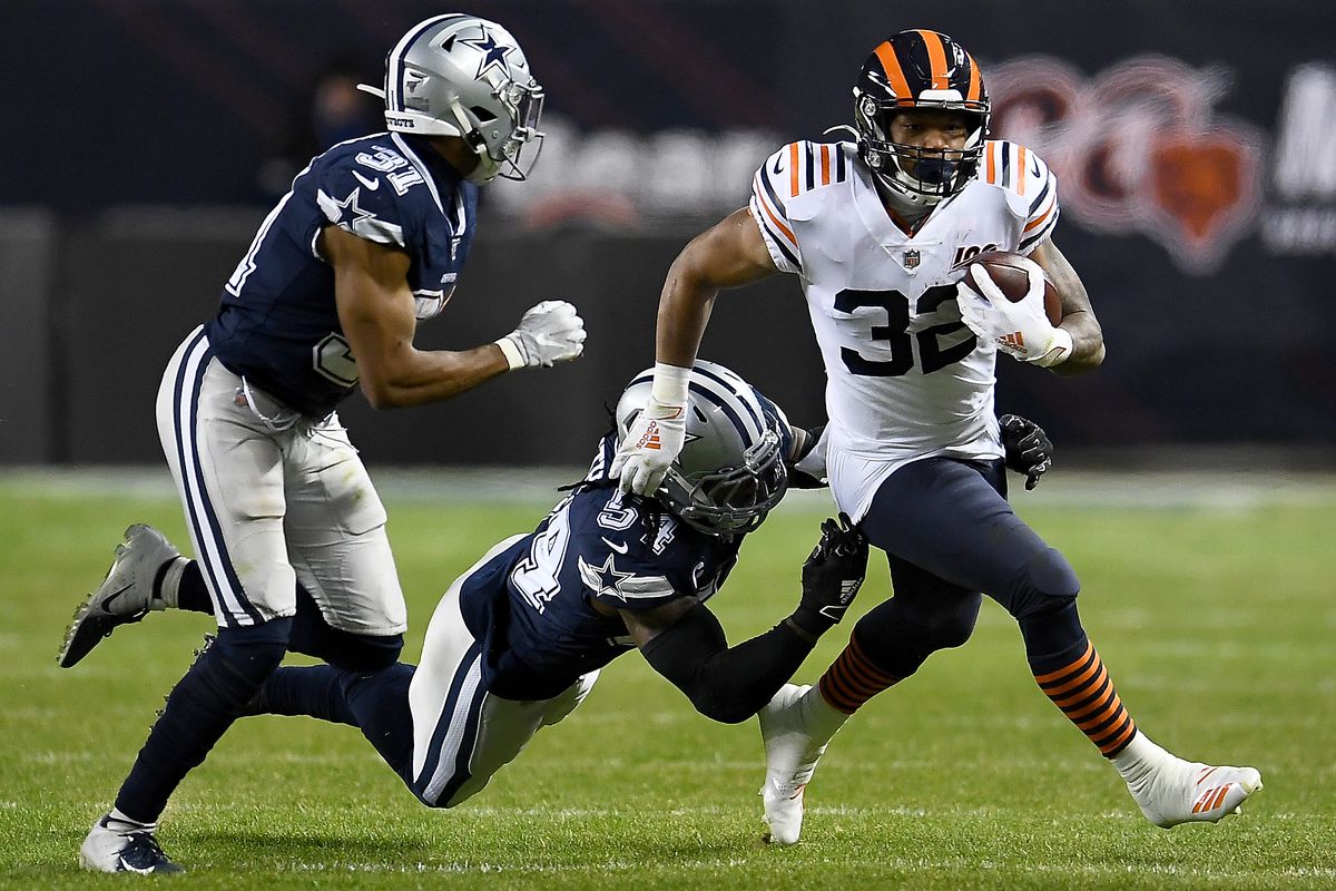 Running back David Montgomery of the Chicago Bears carries the ball against the defense of middle linebacker Jaylon Smith and cornerback Byron Jones of the Dallas Cowboys during the game at Soldier Field on December 05, 2019 in Chicago, Illinois.
