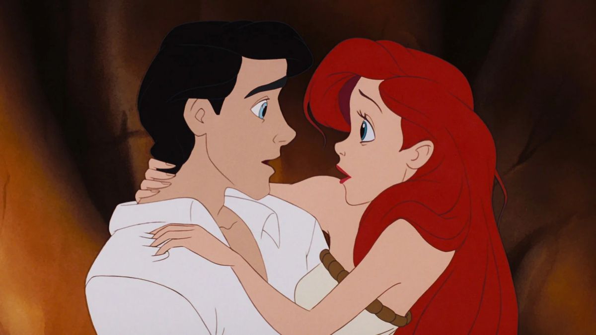 prince eric holding ariel, a redhaired mermaid, after she tries walking for the first time