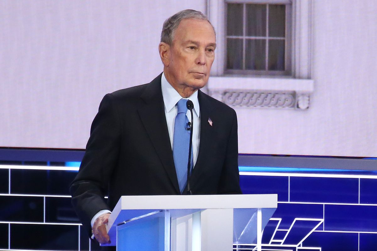 Mike Bloomberg stands at a podium during a debate.
