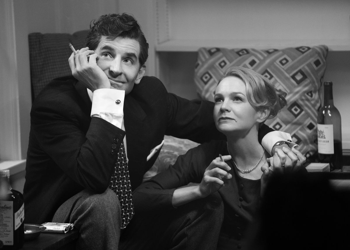 Bradley Cooper as Leonard Bernstein, sitting with his arm around Carey Mulligan 