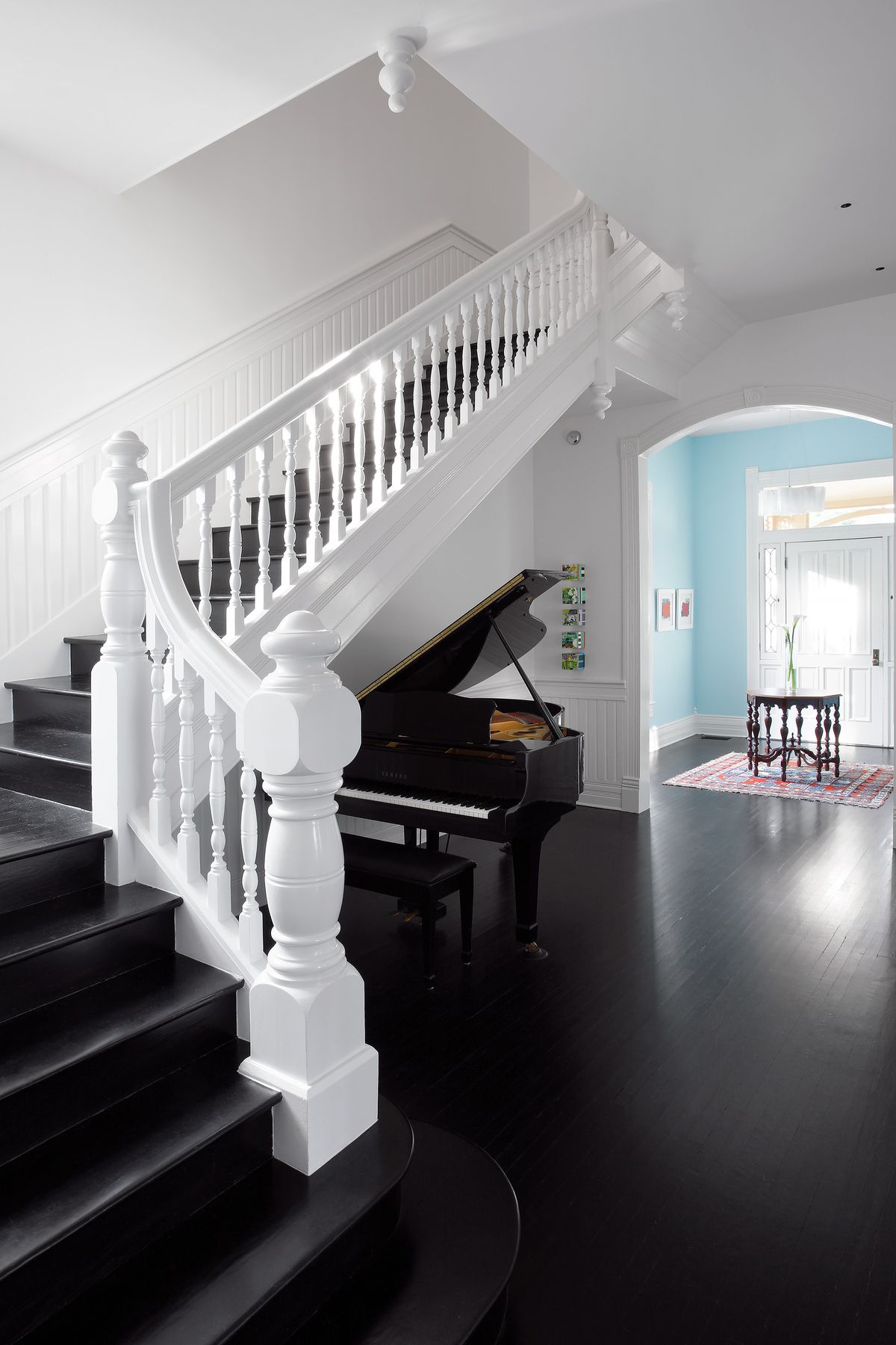 A grand Staircase with a piano under it.