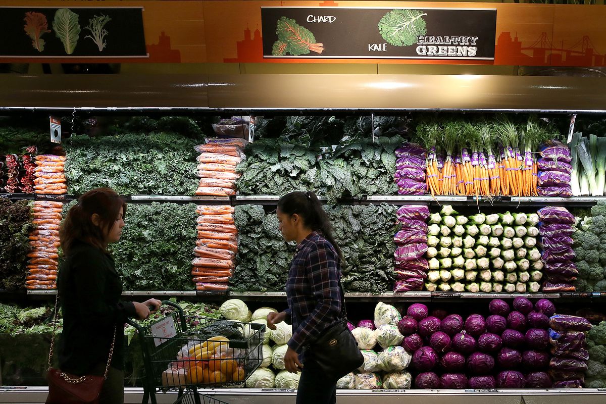 Two customers shopping in a Whole Foods produce department.