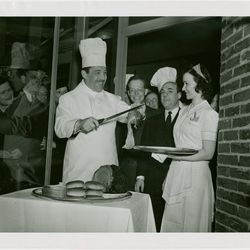 World's Fair Commission President Grover Whalen carving beef at one of the Third Rail Restaurants. Via the <a href="http://digitalgallery.nypl.org/nypldigital/dgkeysearchdetail.cfm?trg=1&strucID=1801303&imageID=1681333&total=5&num=0&word=brass%20rail%20wo