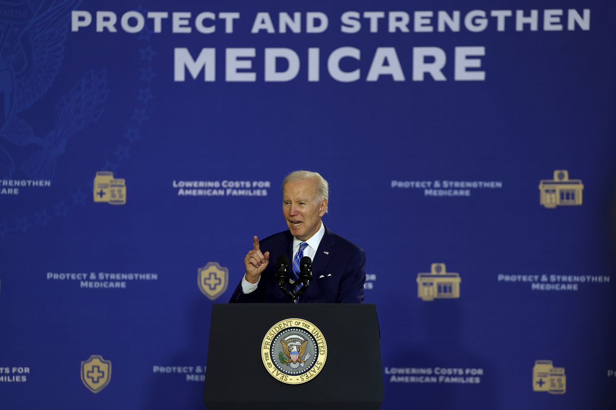 Biden speaks at a lectern in front of a wall that reads “Protect and strengthen Medicare.”