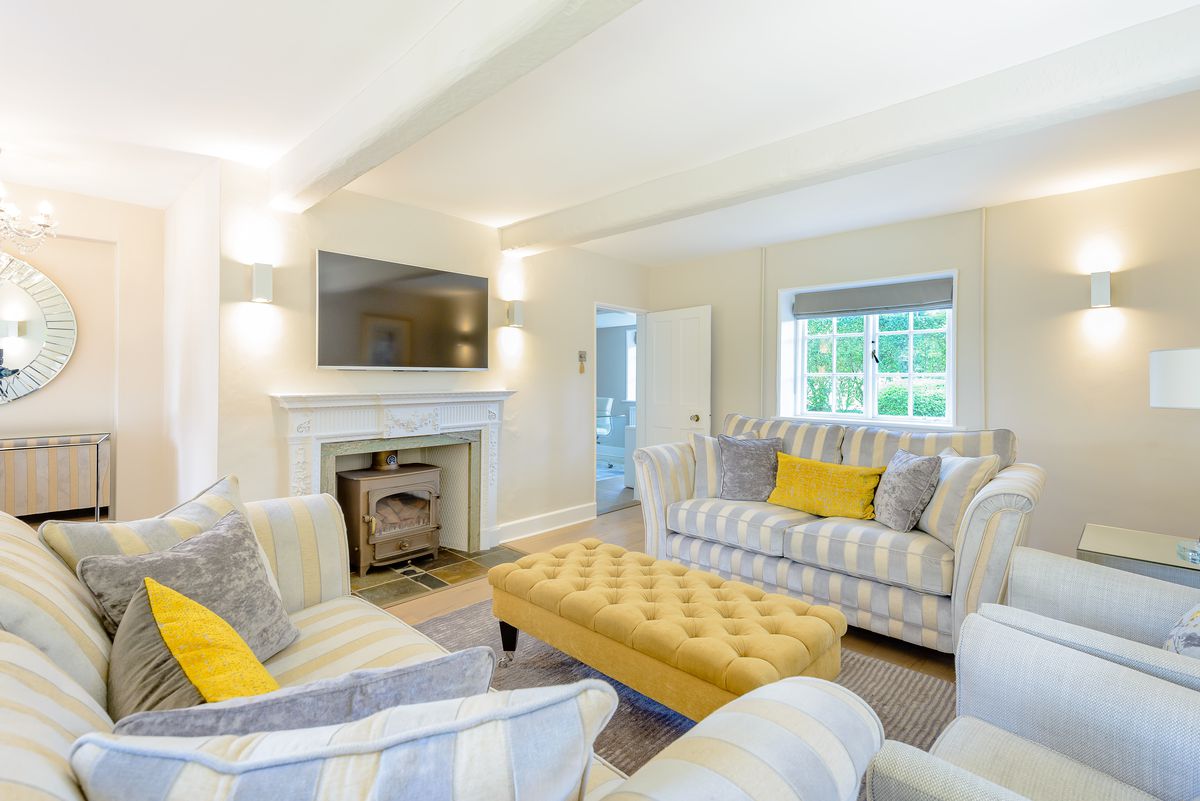 Living room with light blue and yellow furniture and fireplace.