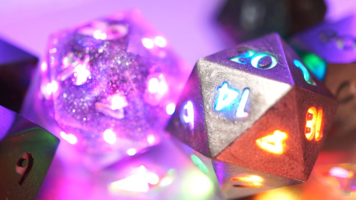 A transparent pink die and a silver metallic die, both with light-up numbers.