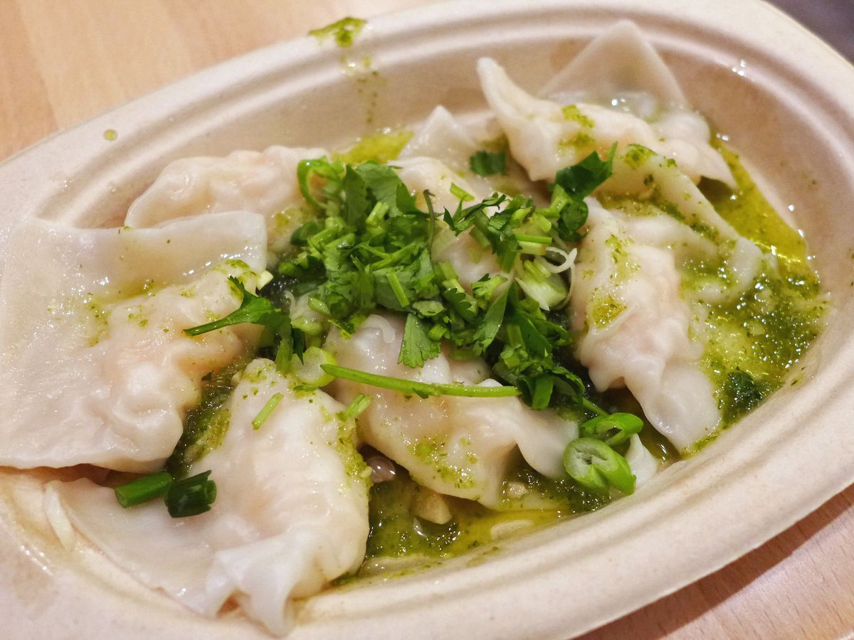 Pale dumplings in a bright green sauce.