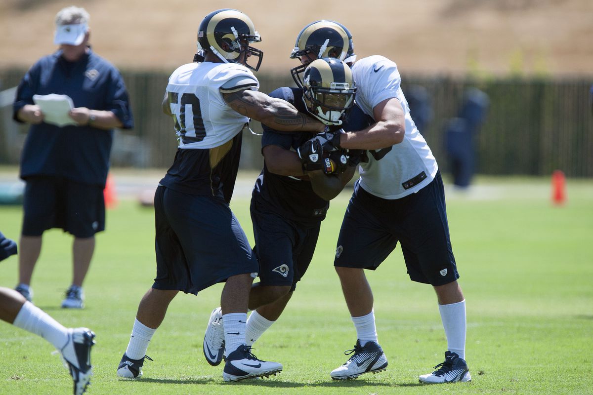 July 27, 2012; St. Louis, MO, USA; St. Louis Rams running back Isaiah Pead (24) is held back by linebacker Aaron Brown (50) and linebacker Noah Keller (53) during training camp at ContinuityX Training Center. Mandatory Credit: Jeff Curry-US PRESSWIRE