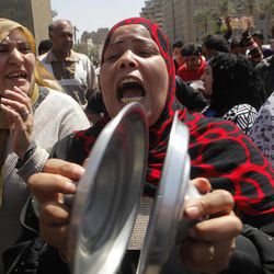An Egyptian woman bangs cooking pot lids together and shouts anti-Muslim Brotherhood slogans during a protest in Tahrir Square, the focal point of Egyptian uprising, to support judicial independence in Cairo, Egypt, Friday, April 26, 2013. Egypt's Islamist-led parliament on Wednesday pushed ahead with a law that could force into retirement many of the nation's most senior judges, despite an uproar by the judiciary over fears the president's allies want to control the courts.