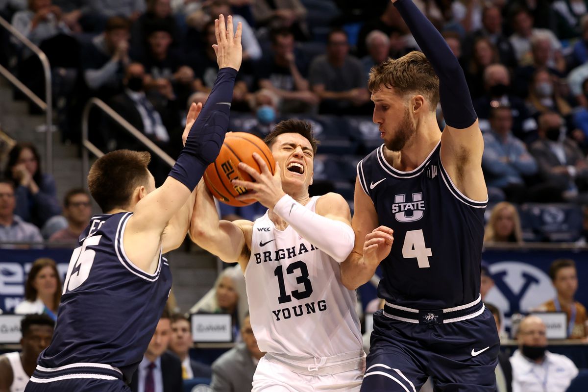 Brigham Young Cougars guard Alex Barcello (13) splits Utah State Aggies guard Rylan Jones (15) and Utah State Aggies forward Brandon Horvath (4) as BYU and Utah State play an NCAA basketball game in Provo at the Marriott Center on Wednesday, Dec. 8, 2021. BYU won 82-71.
