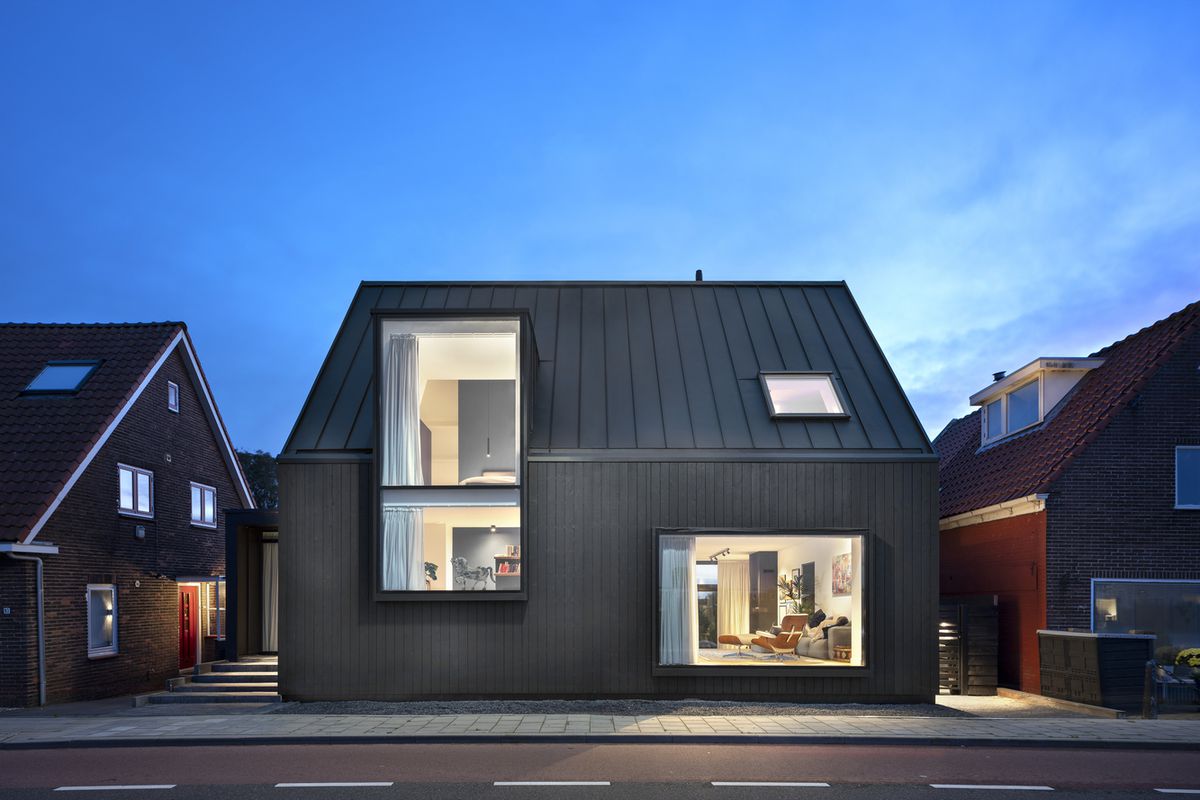 Black house with two large windows facing the street.