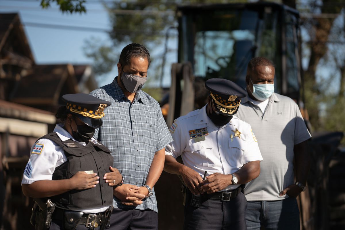 Ald. Anthony Beale (9th) and polic e officers bow their heads during a prayer at a press conference about Operation Clean and safety plans for the Labor Day weekend near West 103rd Street and South Perry Avenue on the Far South Side Friday morning, Sept. 4, 2020. Chicago Police Department and other city agencies participated in Operation Clean, an inter-agency effort that aims to reduce crime and build community relationships, in the 5th District. | Pat Nabong/Sun-Times