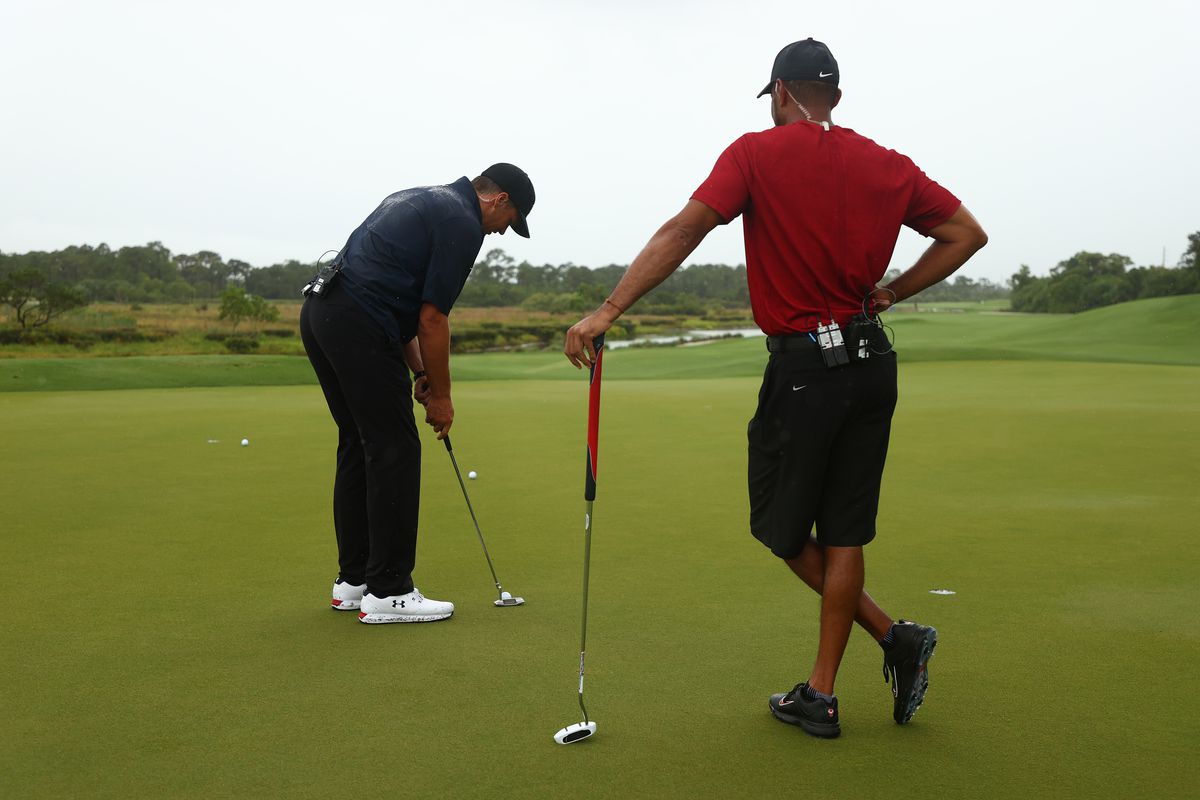 Tiger Woods and NFL player Tom Brady of the Tampa Bay Buccaneers warm up on the practice green during The Match: Champions For Charity at Medalist Golf Club on May 24, 2020 in Hobe Sound, Florida.
