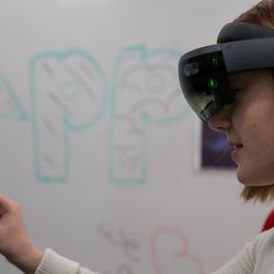 Alyssa Evensen tries out a game using a Microsoft Hololens augmented reality headset at the EAE Play! showcase of games created by the Entertainment Arts & Engineering video game development program at the University of Utah in Salt Lake City on Friday, Dec. 9, 2016.