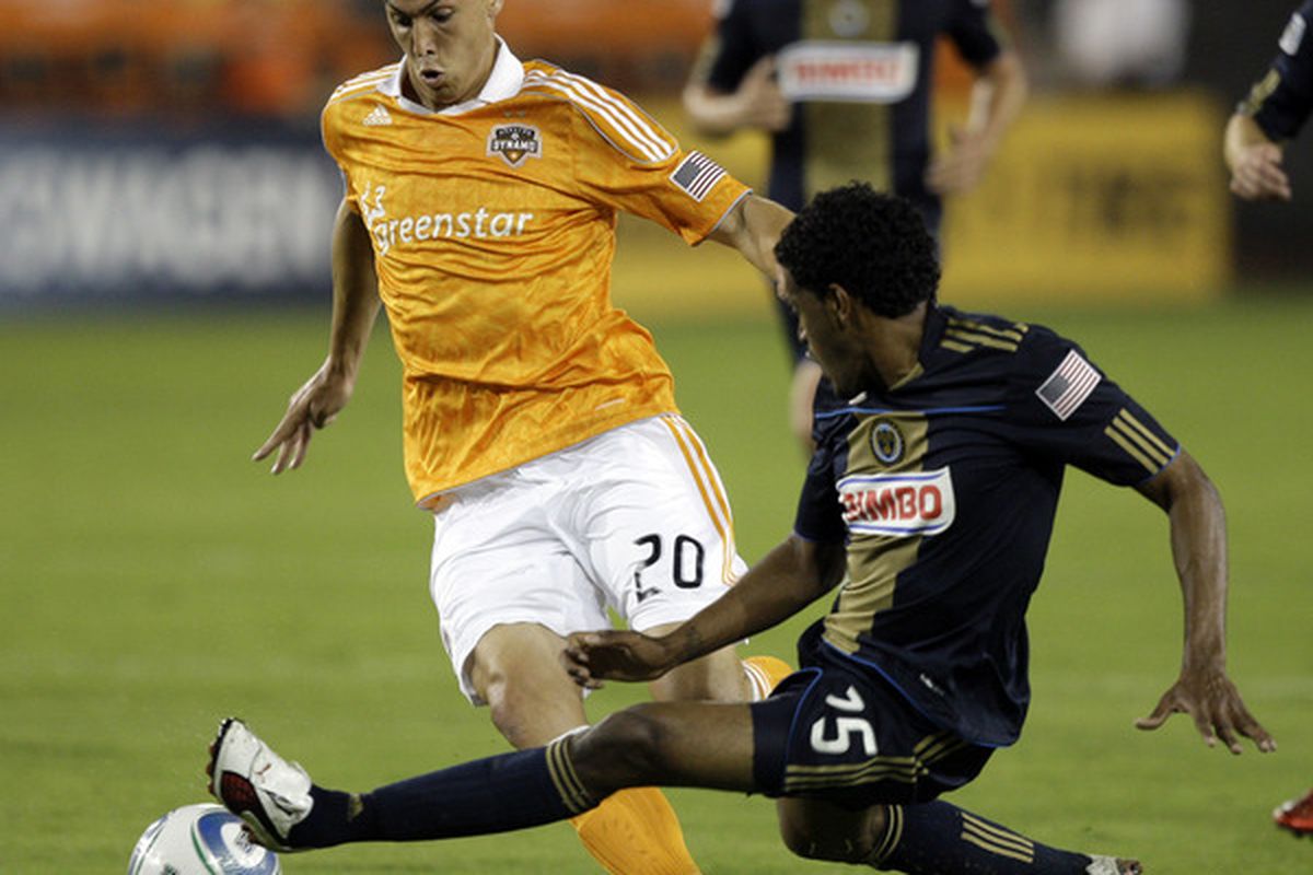 HOUSTON - MARCH 19:  Geoff Cameron #20 of the Houston Dynamo has the ball kicked away by Sheanon WIliams #25 of the Philadlphia Union before he can get to it at Robertson Stadium on March 19, 2011 in Houston, Texas.  (Photo by Bob Levey/Getty Images)