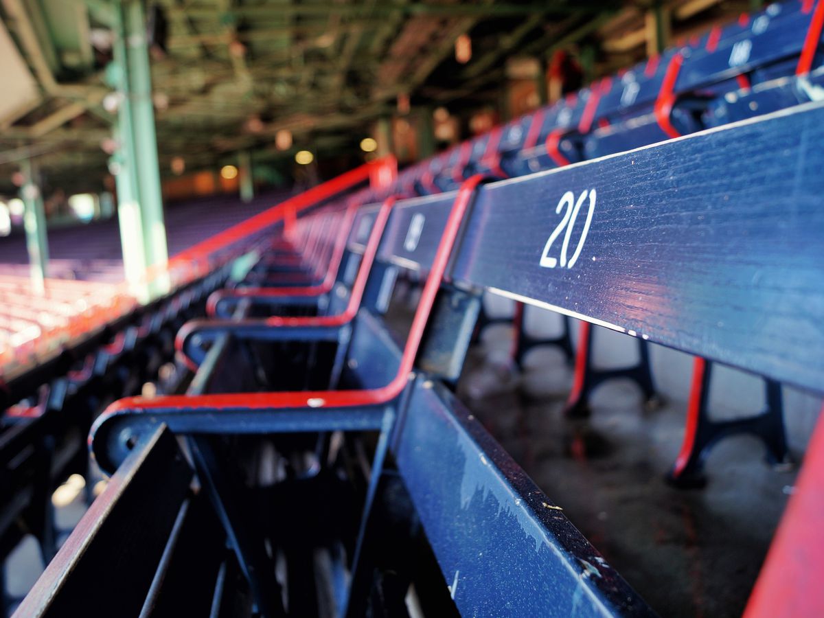 A row of wooden seats in an open-air ballpark. 