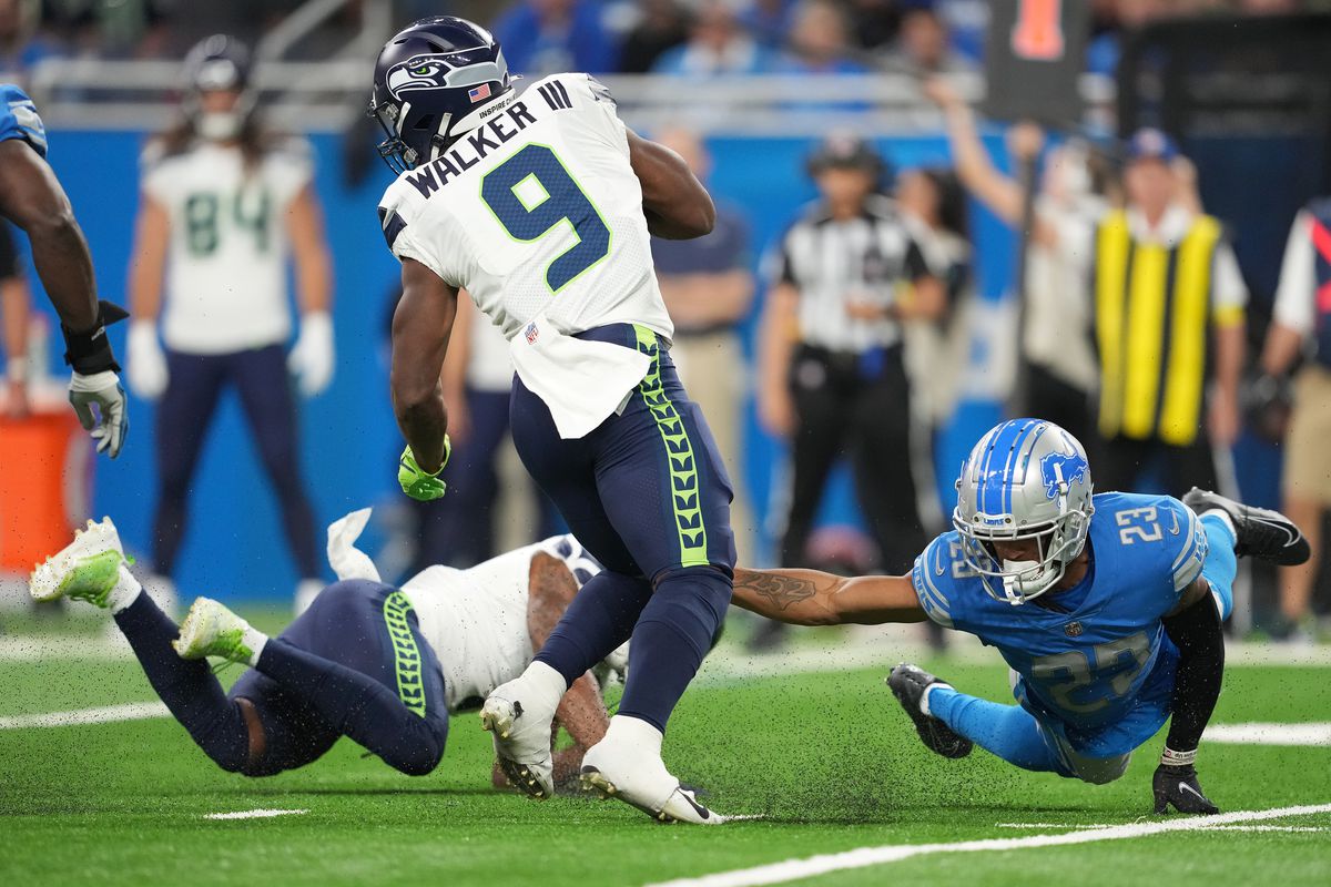 Kenneth Walker III #9 of the Seattle Seahawks is tackled by Mike Hughes #23 of the Detroit Lions during the third quarter at Ford Field on October 02, 2022 in Detroit, Michigan.