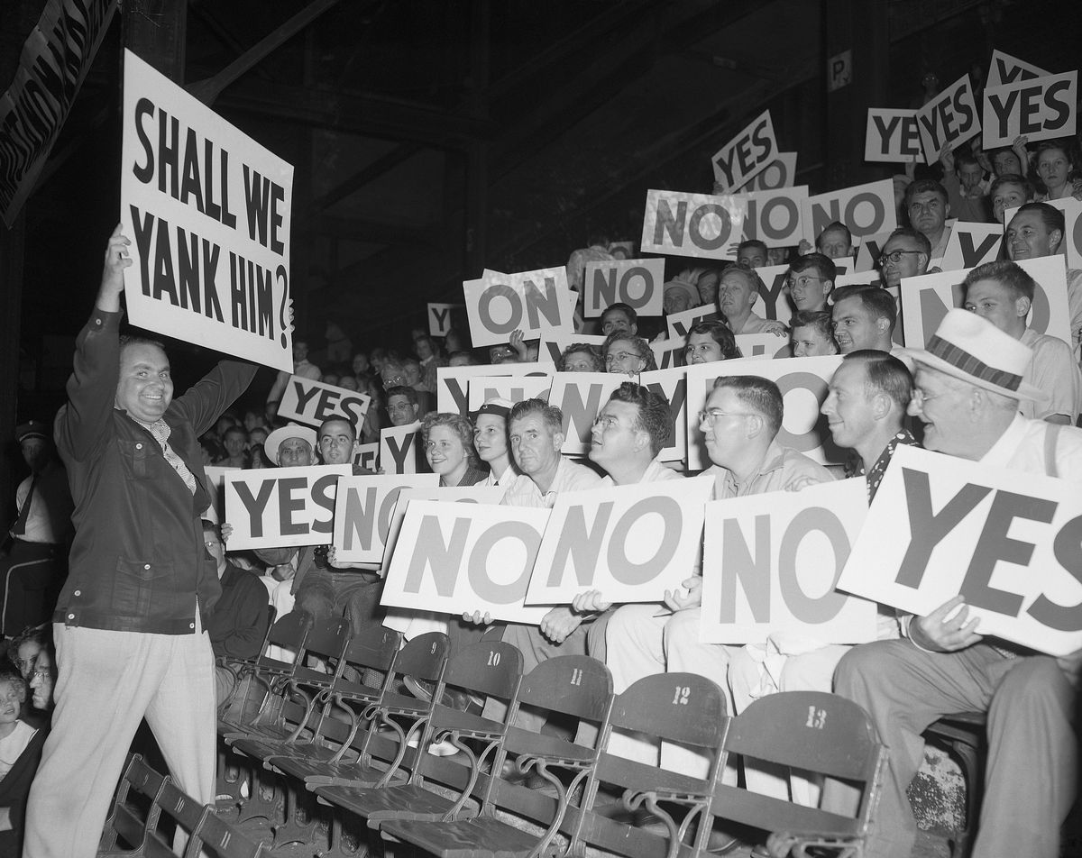 Man Holding Sign near Grandstand Audience