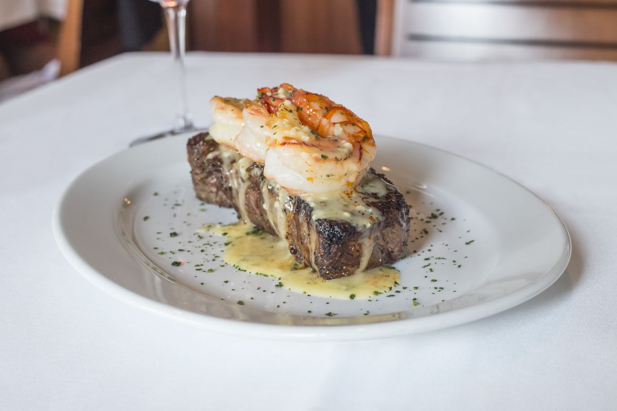 A steak with shrimp on top